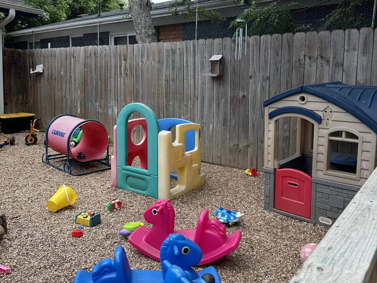 Toddler play area with a playhouse, tunnel and rocking toys